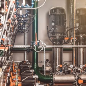 Industrial interior of water pump, valves, pressure gauges, motors inside engine room. Industry pumps in an technical room with modern powerful pipelines, automatic control systems. Copy text space